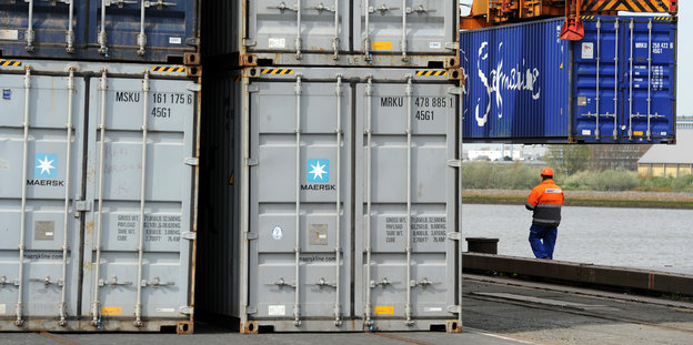 Ein BLG-Mitarbeiter steht neben Containern.