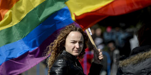 Eine Frau schwenkt eine Regenbogenfahne