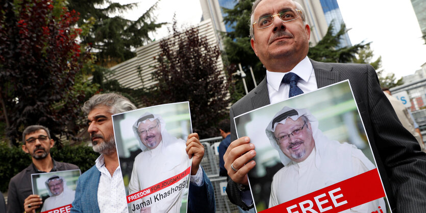 Deri Männer halten Plakate mit Fotos von Jamal Khashoggi