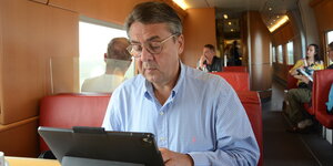 Sigmar Gabriel sitzt an seinem Tablet im Zug