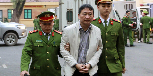Trinh Xuan Thanh umgeben von zwei vietnamesischen Polizisten