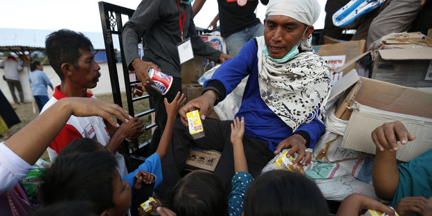 In Indonesien verteilen Freiwillige Lebensmittel an Betroffene