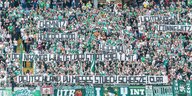 Werder-Fans halten antirassistsiche Spruchbänder hoch