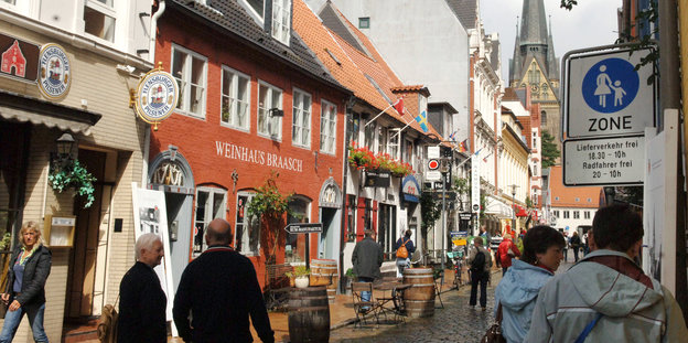 Menschen gehen durch die Flensburger Altstadt.