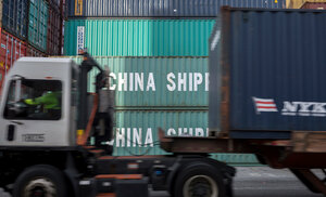 Ein Lastwagen fährt im Hafen von Savannah an Containern aus China vorbei