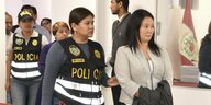 Eine Polizistin führt Keiko Fujimori vor sich her