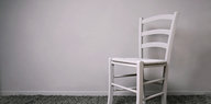 Ein weißer Stuhl steht in einem ansonsten leeren Zimmer