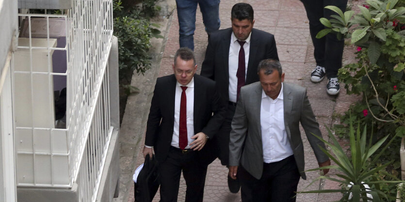 In der Türkei läuft Andrew Brunson mit anderen Männern an einem Haus vorbei