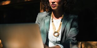 Eine Frau in schicker Kleidung arbeitet an einem Laptop