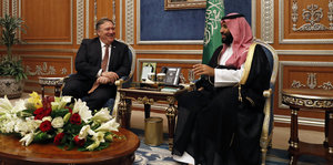 Mike Pompeo sitzt neben Mohammed bin Salman, im Hintergrund ist eine saudi-arabische Flagge zu sehen