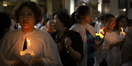 Gläubige Chinesinnen tragen Kerzen bei einer Messe