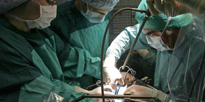 Grün gekleidete Ärzte bei einer Nieren-OP