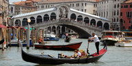 Touristen werden in Gondeln durch Venedig kutschiert.