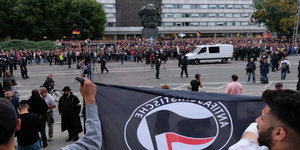 Zwei Teilnehmer einer Gegendemonstration gegen Rechts hebe eine Antifa-Fahne in die Luft