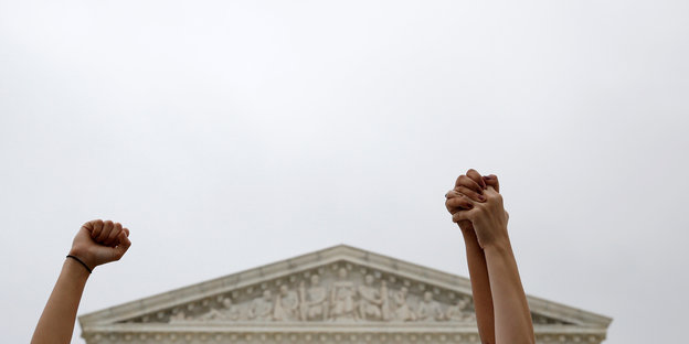 Demonstrantinnen vor dem Supreme Court in Washington haben ihre Arme in die Luft gehoben