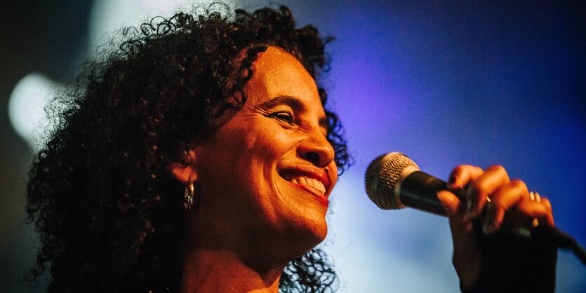 Neneh Cherry hält ein Mikrofon