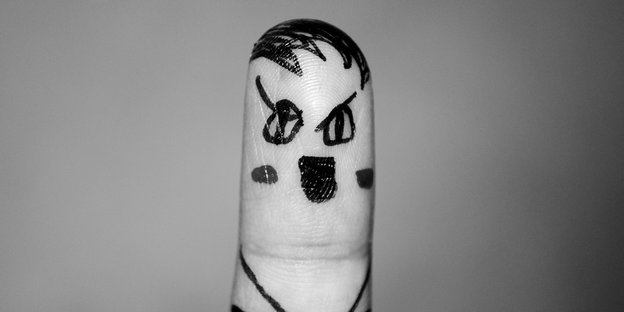 Auf einem Finger ist ein Adolf Hitler gezeichnet