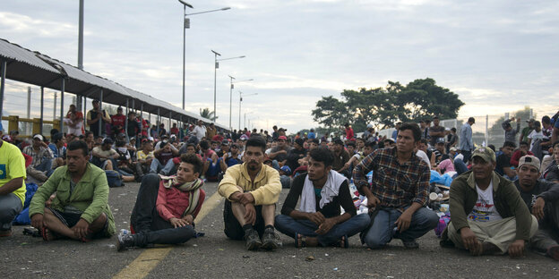 Mehrere Menschen sitzen auf einer Straße