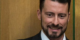 Andreas Lichert steht vor einer Wand