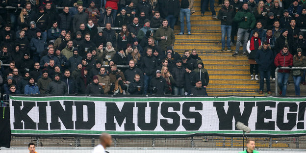 Fans hinter einem Banner mit der Aufschrift "Kind muss weg".