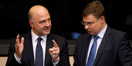 Zwei Männer, Pierre Moscovici und Valdis Dombrovskis, unterhalten sich