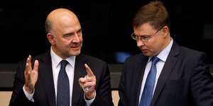 Zwei Männer, Pierre Moscovici und Valdis Dombrovskis, unterhalten sich