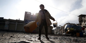 Ein Junge im Jemen mit zwei großen Kanistern