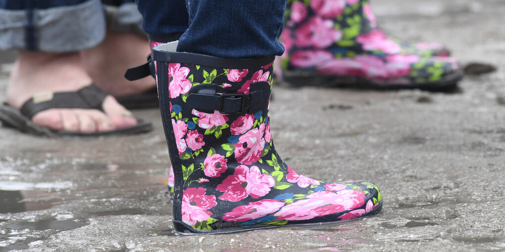 Ein pinker Gummistiefel im Matsch