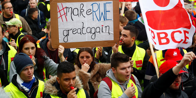 Demonstrantinnen halten ein Schild, auf dem "Make RWE Great Again" steht