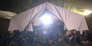 Aktivisten des Aktionsbündnisses «Ende Gelände» sitzen kurz vor der Räumung ihres Camps vor einem Zelt.