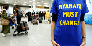 Eine Frau trägt ein T-Shirt mit der Aufschrift "Ryanair must change"