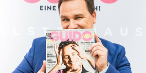Guido Maria Kretschmer hält sein Magazin in den Händen.