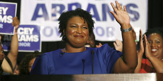 Stacey Abrams winkt bei einer Wahlkampfveranstaltung