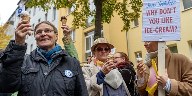 Drei ältere, weiblich Demonstrantinnen essen Eis und halten ein Schilde mit der Aufschrift "Taekker, why don't you like ice cream" hoch
