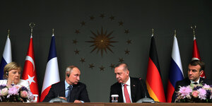 Merkel, Putin, Erdogan und Macron sitzen nebeneinander und wiegen bedächtig die Köpfe