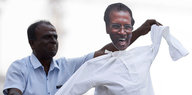 Ein Unterstützer von Sri Lankas Primeminister tanzt mit einer Puppe von Präsident Maithripala Sirisena