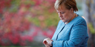 Bundeskanzlerin Angela Merkel schaut auf ihre Armbanduhr