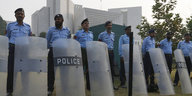 Polizisten mit Schutzschildern stehen vor einem Gebäude