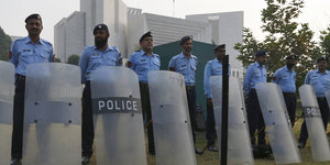 Polizisten mit Schutzschildern stehen vor einem Gebäude