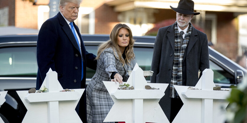 Donald Trump steht mit seiner Frau Melania und einem Rabbi am Gedenkort für die in Pittsburgh getöteten Menschen