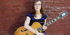 Mary Halvorson hält eine Gitarre