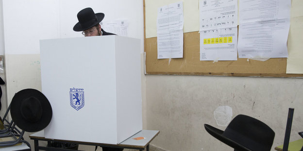 Ein ultraorthodoxer Jude gibt seine Stimme bei den Kommunalwahlen in einem Wahllokal ab