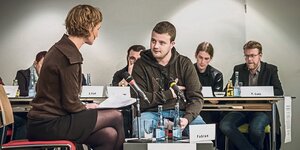 Ein junger Mann spricht mit einer Frau beim Hamburger "Tribunal zur Heimerziehung".