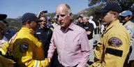 Jerry Brown schüttelt einen Feuerwehrmann die Hand