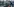 Ein Mensch sitzt auf der Straße, ein andere beugt sich zu ihm