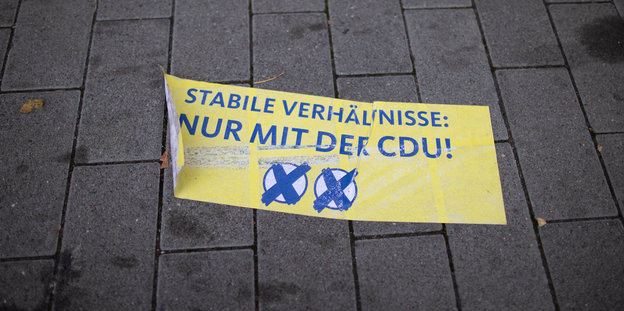 Ein gelbes Transparent liegt auf dem Bürgersteig. Darauf steht: "Stabile Verhältnisse: Nur mit der CDU!"