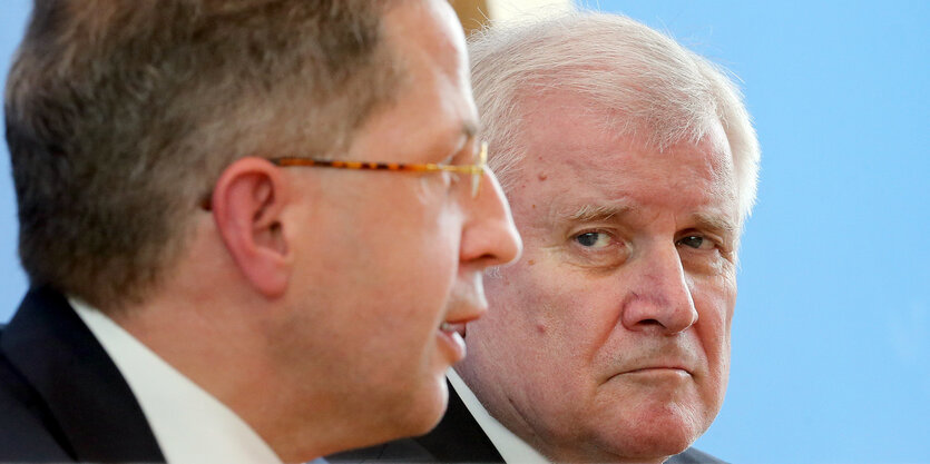 Hans-Georg Maaßen blickt zur Seite, Seehofer guckt missmutig zu ihm