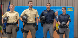 Polizisten mit alter und neuer Polizeiuniform stehen nebeneinander