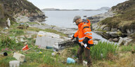 Ein Freiwilliger sammelt Müll vor der Küste Norwegens ein