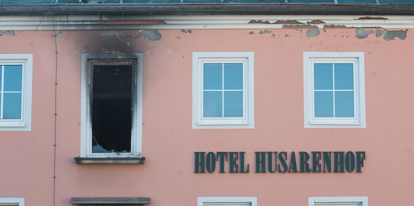 Ein ausgebranntes Fenster in einem lachsfarbenen Haus